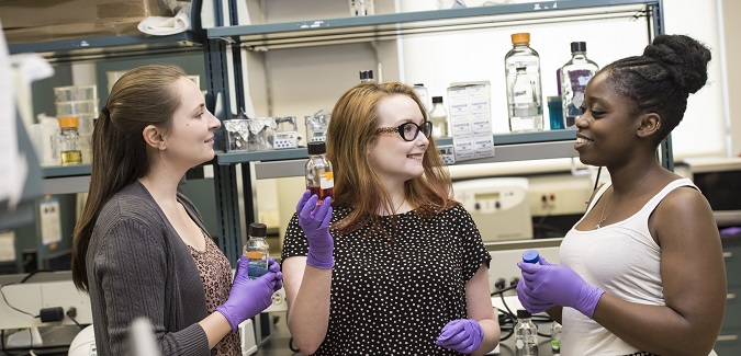 Three students in a laboratory environment